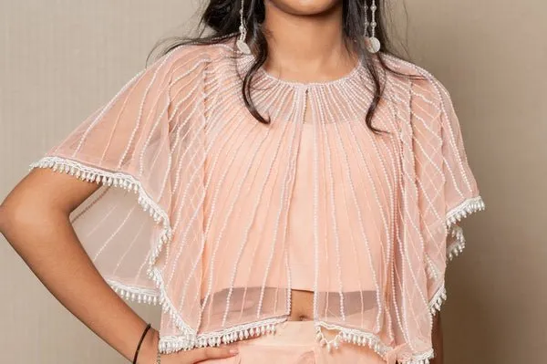 Chic Peach ensemble with beaded cape and ruffled palazzo pants, perfect for a stylish and elegant look at any occasion.